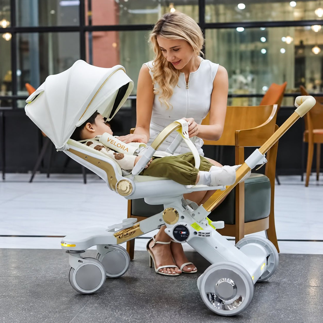 Peuter in de VELORA kinderwagen Serenade in beige en goud, het 360° draaibare zitje is naar de ouder gedraaid