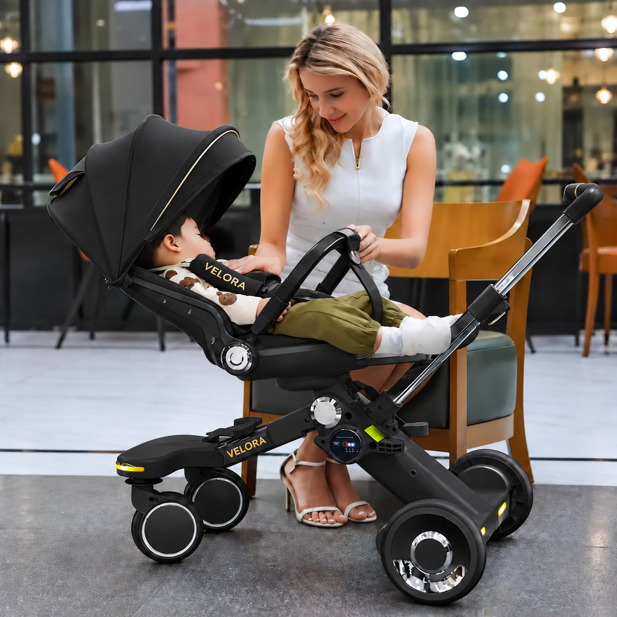 Toddler in the Black VELORA Electric Stroller with the 360-degree seat turned to face the parent